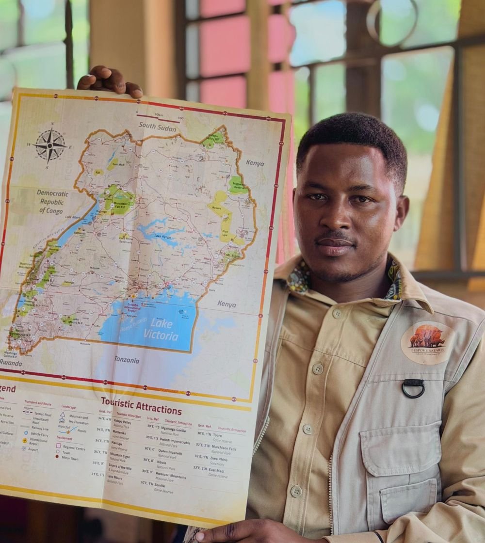 James Mutabazi, Founder and CEO of Bespoke Safaris, holding a map of Uganda